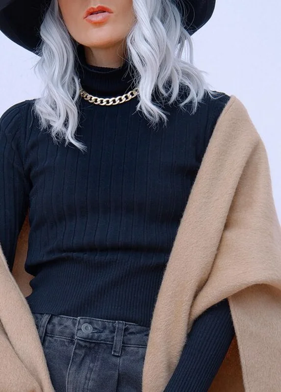 Modelka w swobodnym stroju jesienno-zimowym z czarną czapką i wełnianym szalikiem