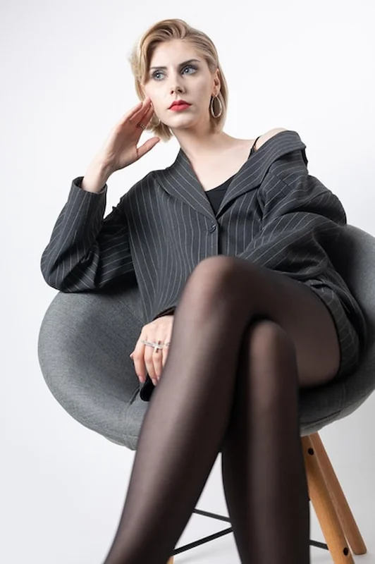 Kobieta w garniturze z długimi nogami w rajstopach w studiu