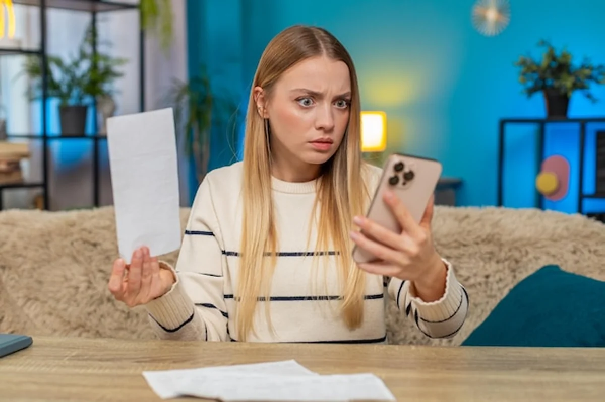 Biała kobieta sprawdza smartfon z rachunkami