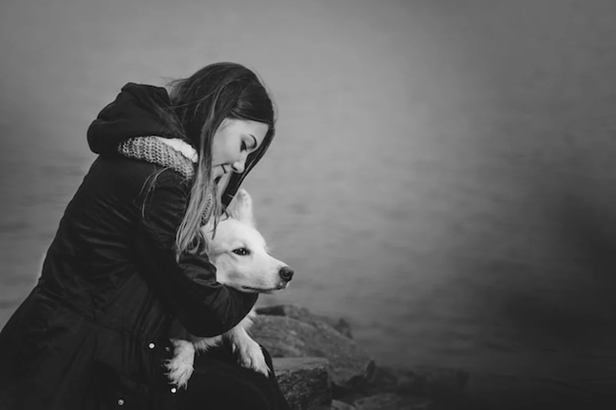 Młoda kobieta przytula i całuje swojego psa