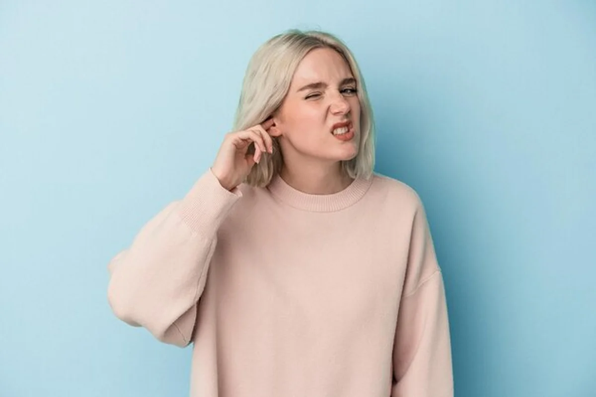 Osoba zakrywająca uszy palcami w stresie