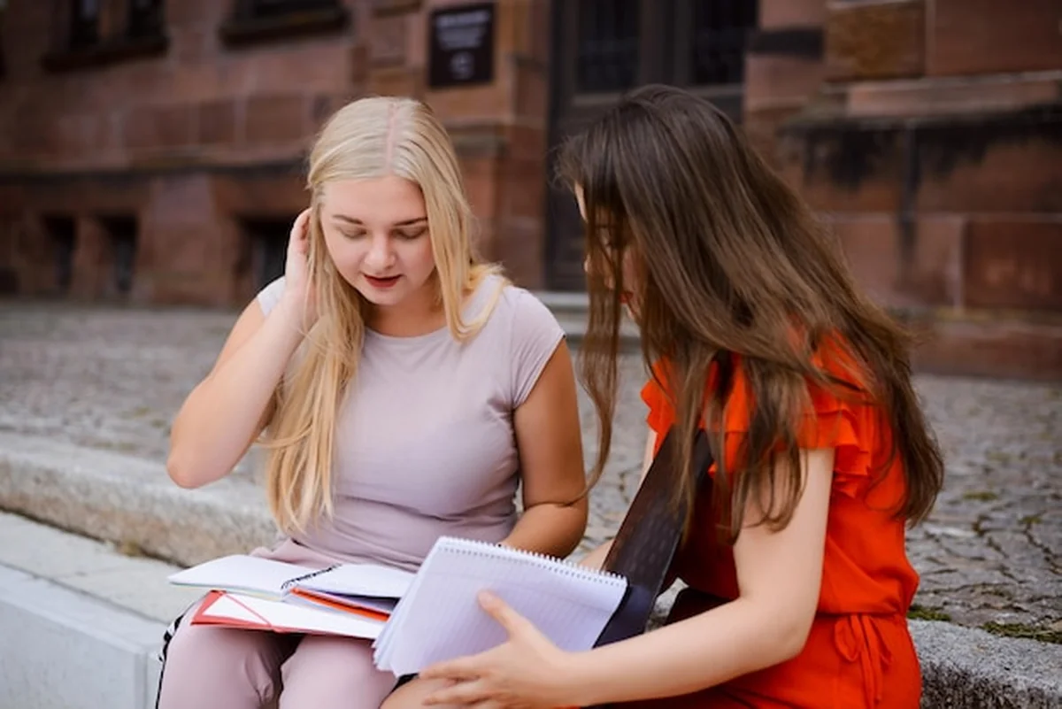 Dwie studentki siedzące na schodach uniwersytetu