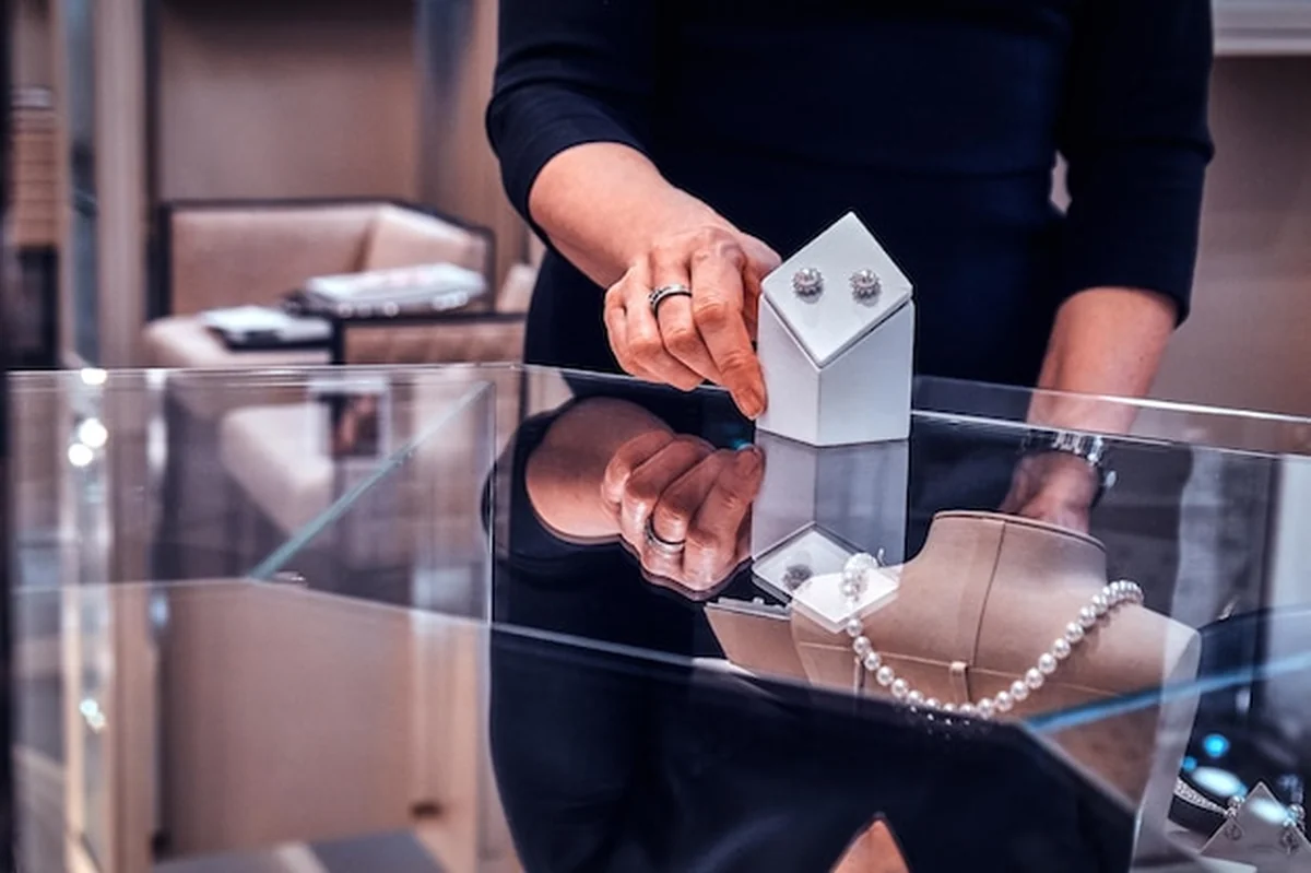 Elegancka sprzedawczyni prezentuje klientce piękne kolczyki z pereł