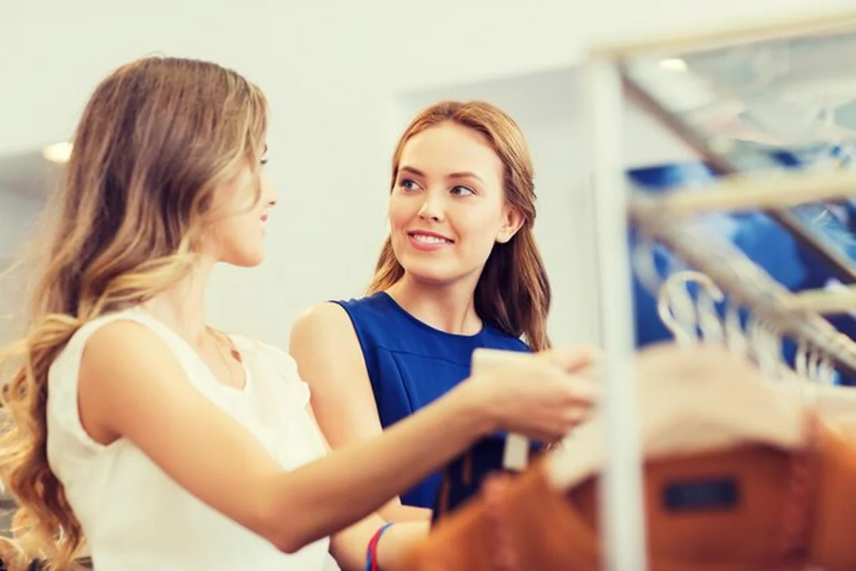 Młode kobiety wybierające ubrania w sklepie odzieżowym