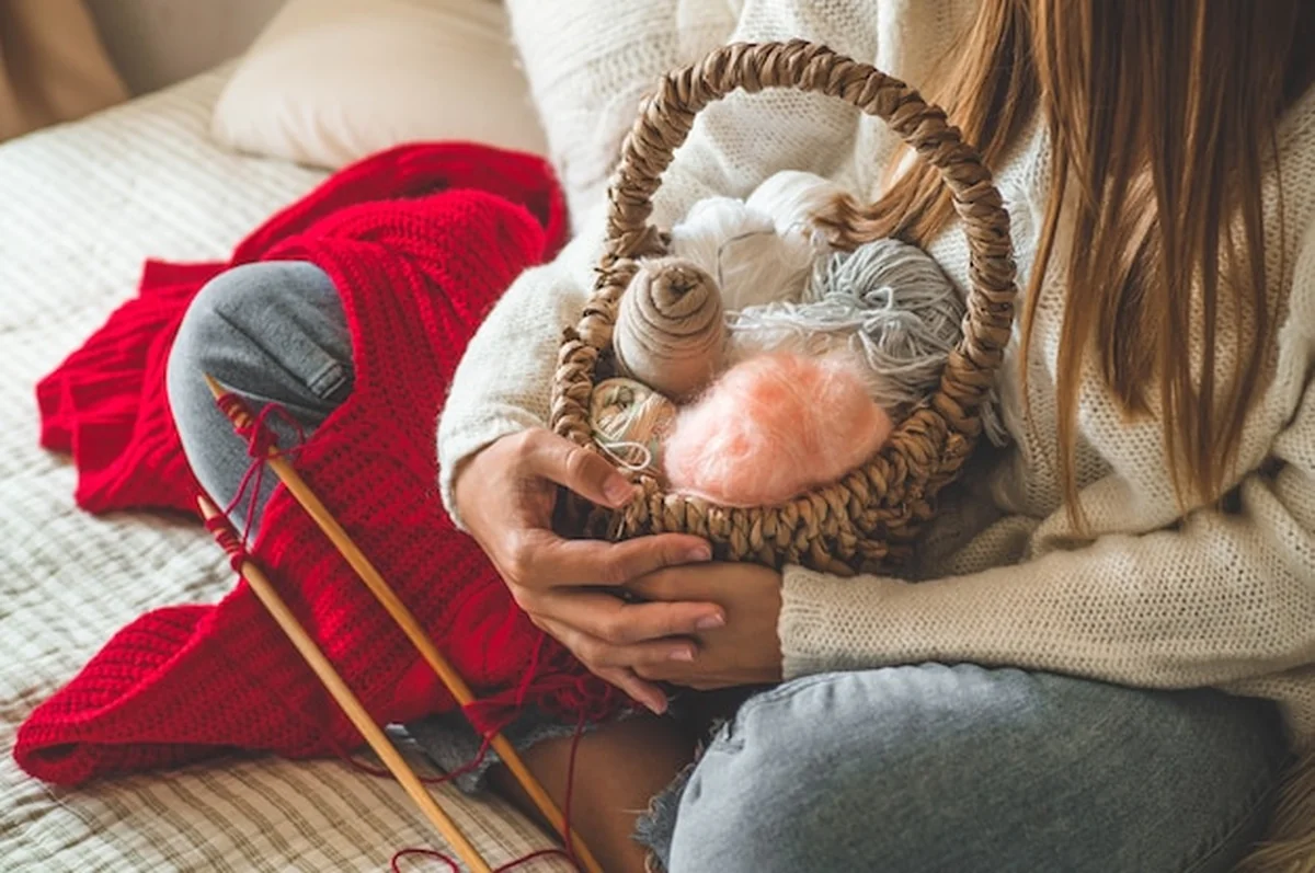 Dziewczyna robi na drutach na łóżku