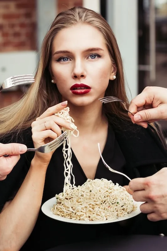 Piękna kobieta jedząca makaron rękami