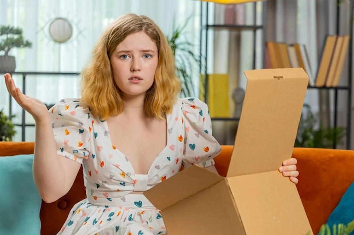 Młoda kobieta otwierająca błędną paczkę na Vinted