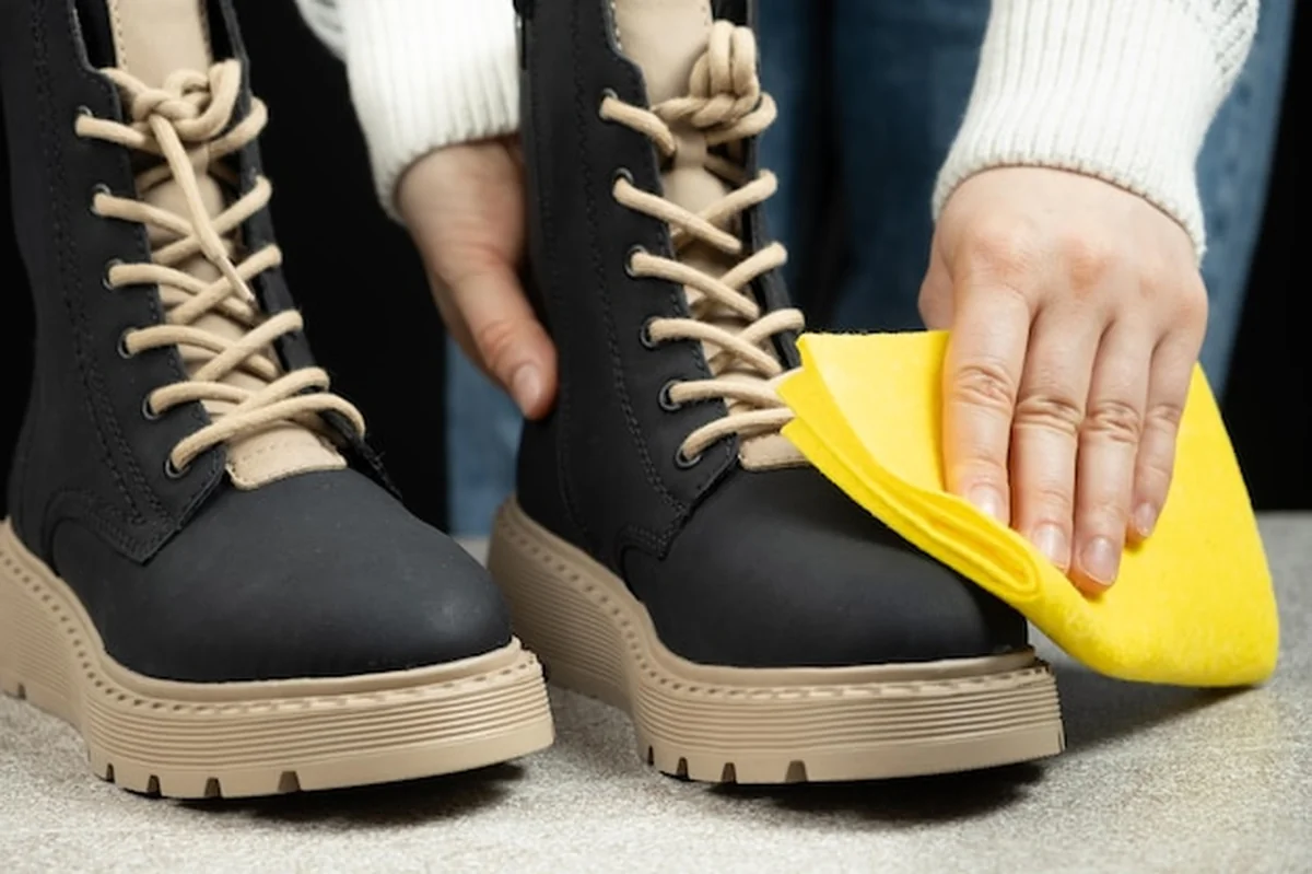 Kobieta wycierająca skórzaną powierzchnię butów