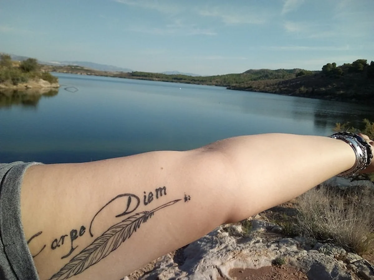 Ręka z tatuażem na jeziorze