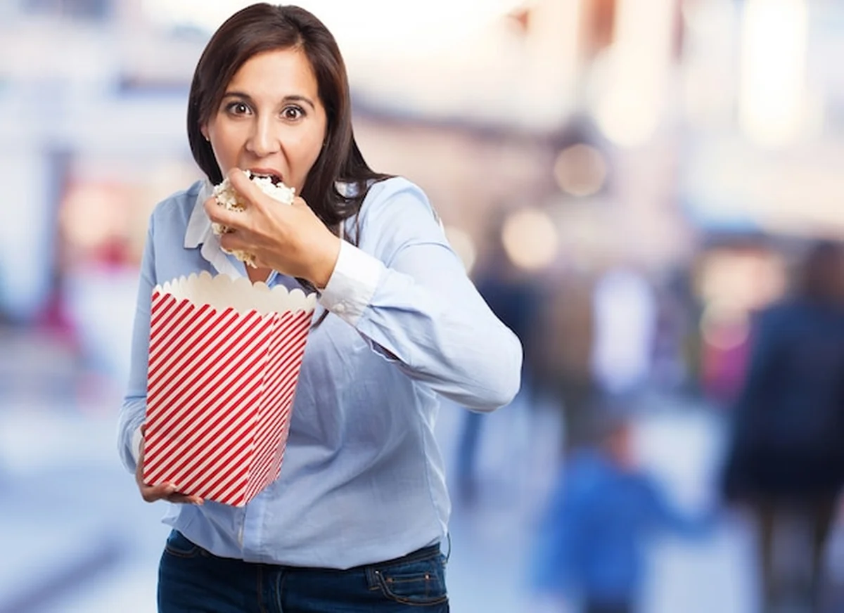 Kobieta jedząca popcorn w kinie Helios