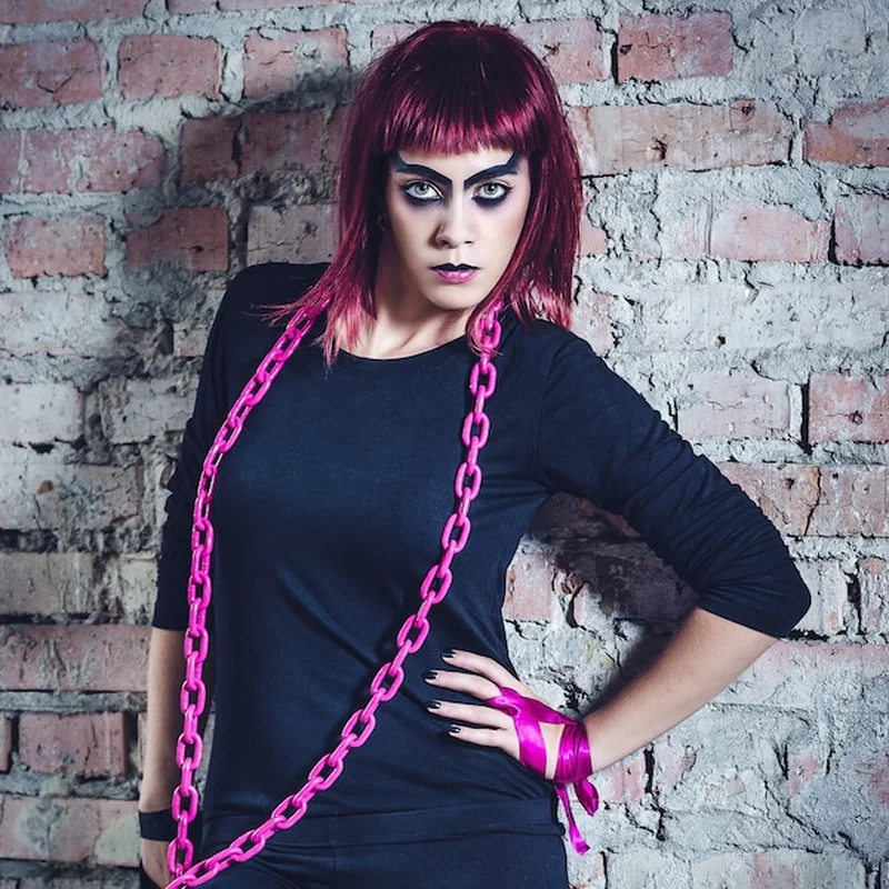 Modelka w czarnym stroju z różowymi włosami w opuszczonym budynku