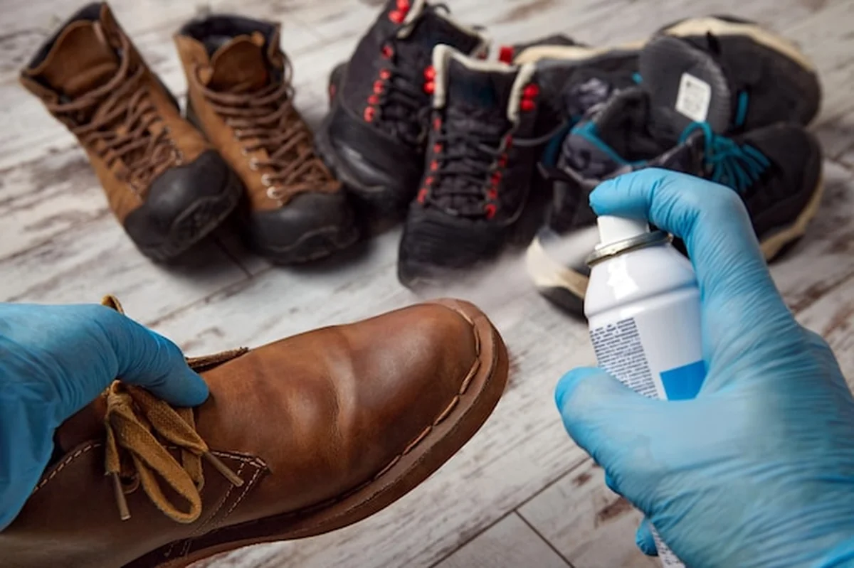 Mężczyzna impregnuje buty lateksowymi rękawiczkami