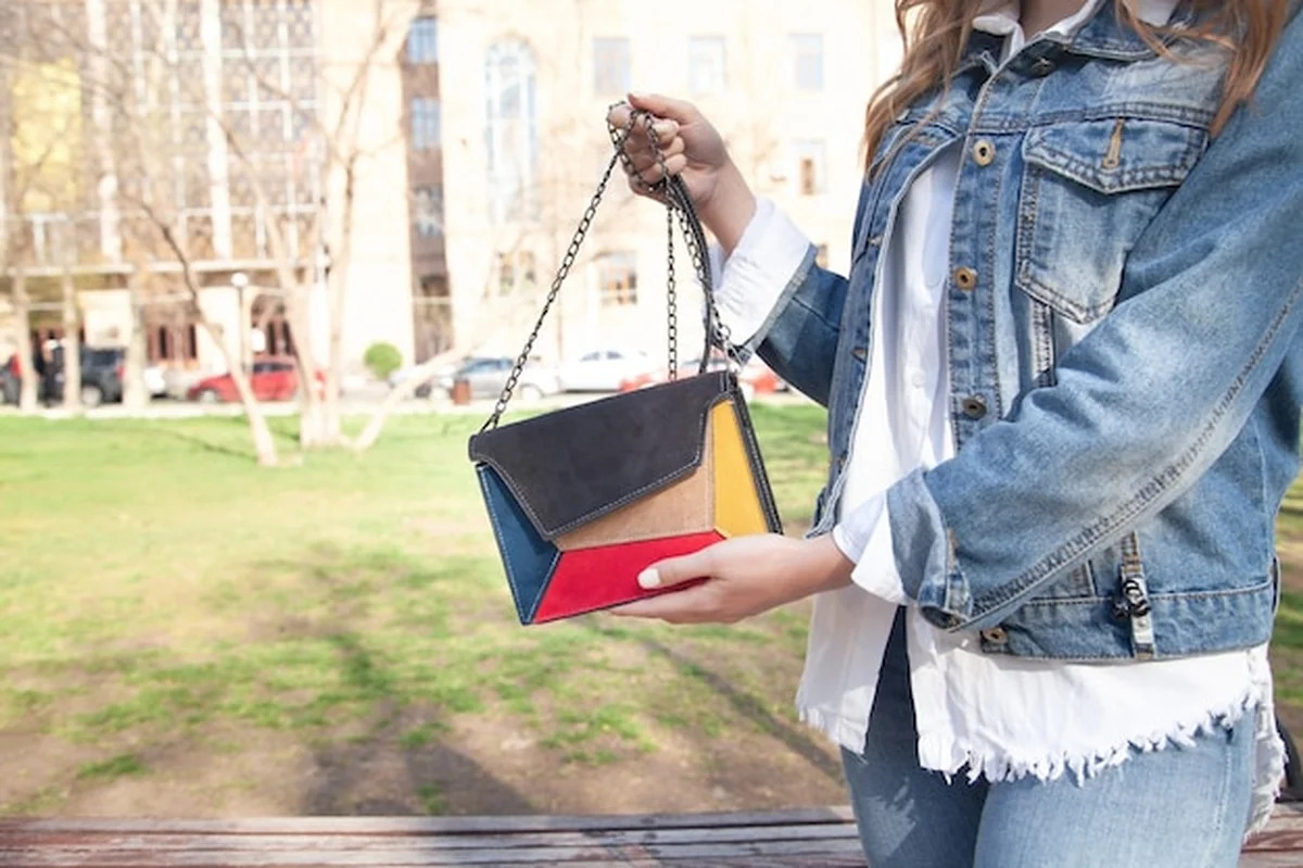 Młoda kobieta z torebką w plenerze