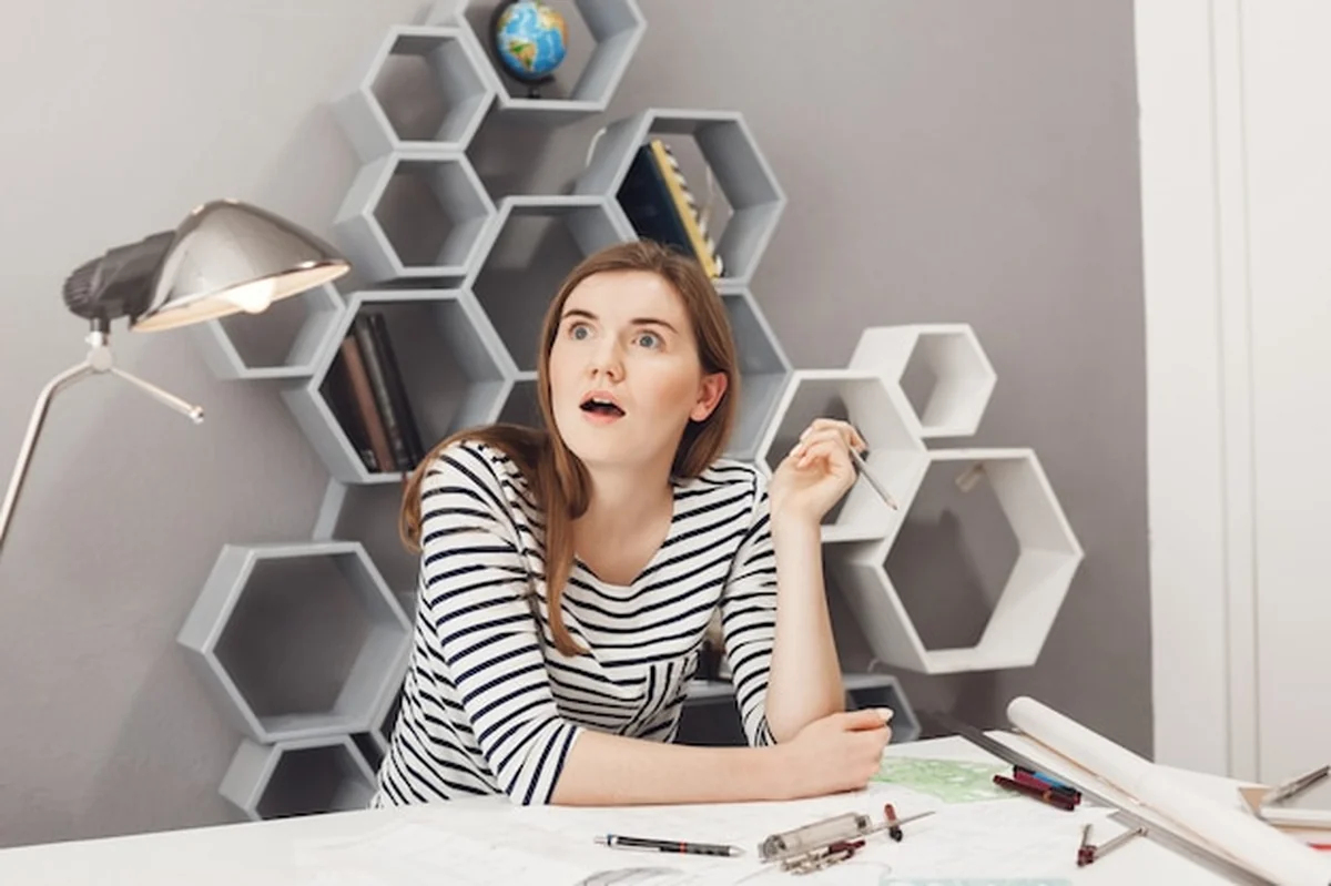 Młoda architektka w pasiastej koszuli pracuje w biurze nad projektem zespołowym