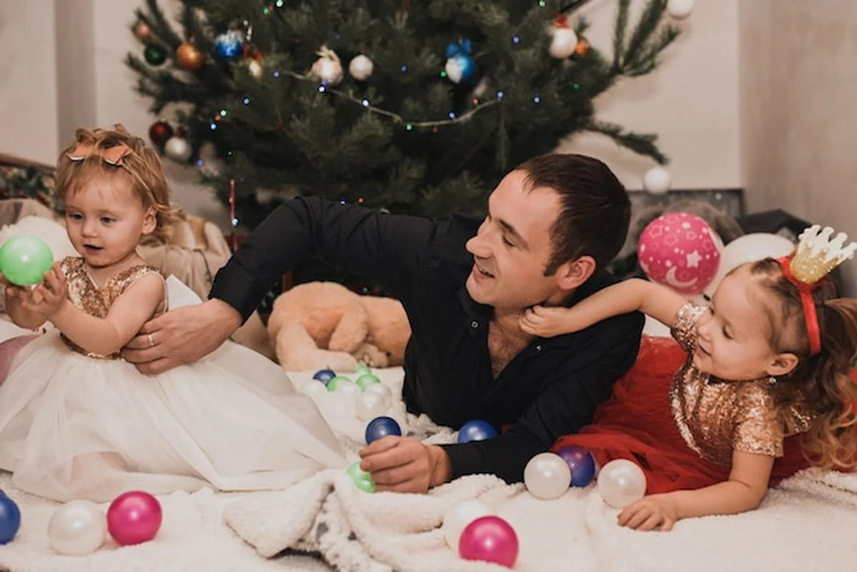 Szczęśliwa rodzina z dziećmi przy ozdobionych choinkowych girlandach