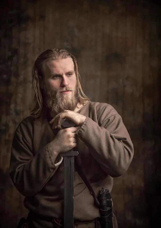 Młody człowiek z mieczem przy ścianie