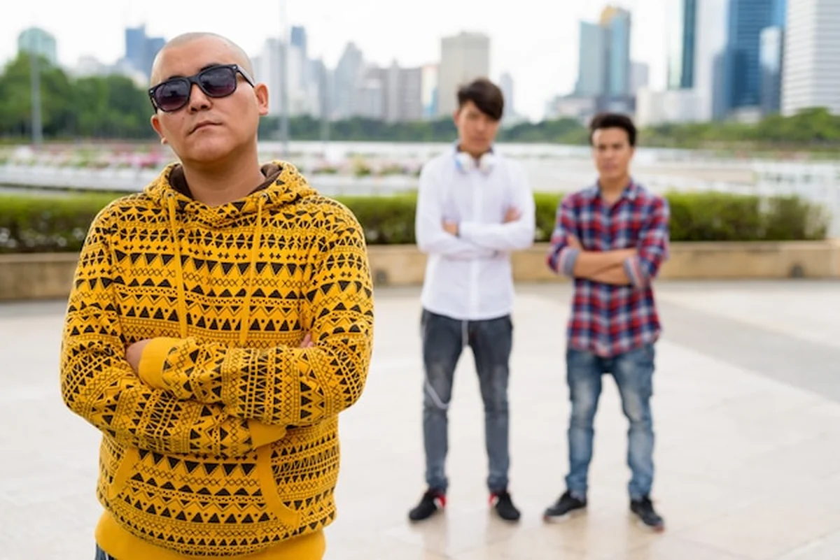 Trzech młodych mężczyzn azjatyckich relaksuje się w parku w Bangkoku, Tajlandia