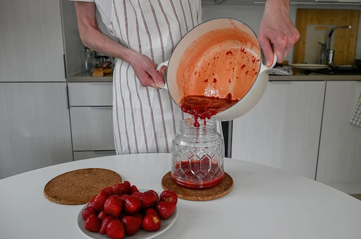 Osoba robiąca słodki dżem z truskawek
