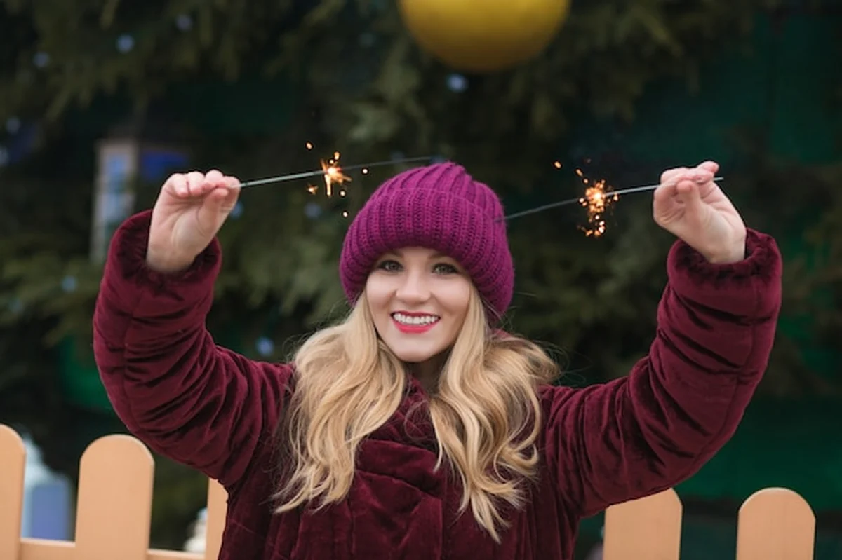 Blondynka bawi się światłami na noworocznym świerku w Kijowie